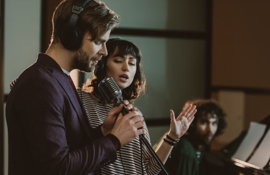 Alumno y profesora adultos ensayando en un estudio de canto durante una clase de formación voca