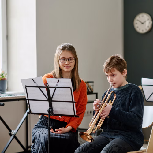 Profesora de música impartiendo una clase personalizada a un adolescente en una escuela de música en Madrid