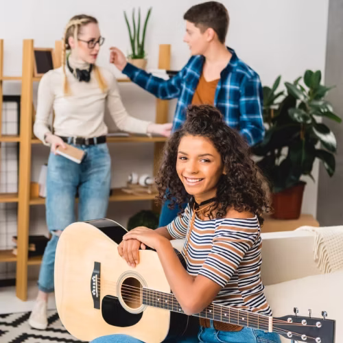 Grupo de adultos jóvenes participando en una clase de música con instrumentos en una escuela de música en Madrid