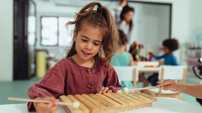 Niña de 8 años usando una partitura durante una clase de música